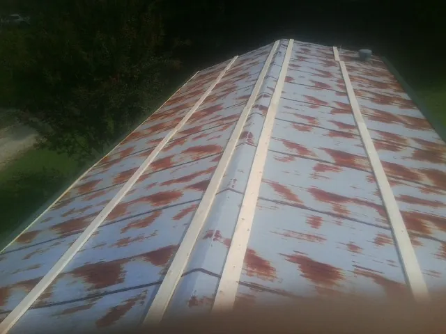 Rusted metal roof panels with new wood purlins before replacement — Storm Damage Roof Repair in Alvaton by Roofing Brothers