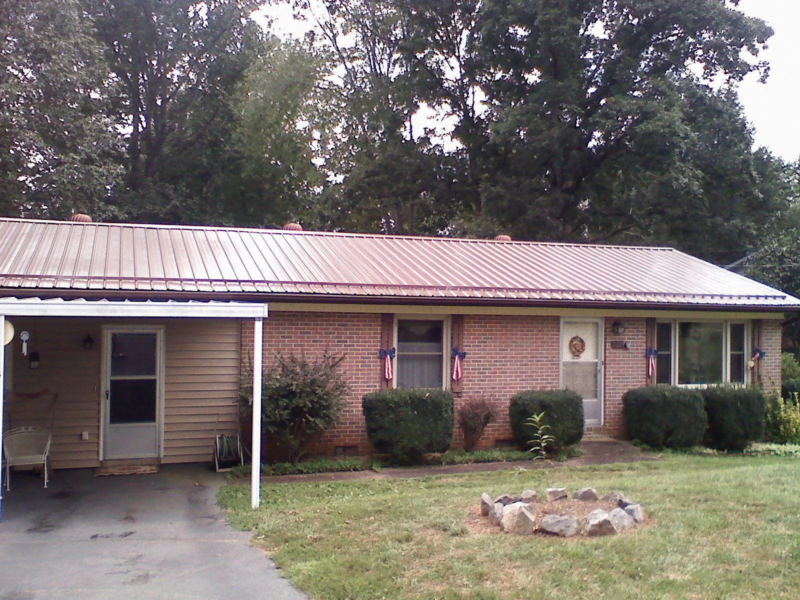 Bronze metal roof and carport on a brick ranch home — Roof Repair work by our crew in Alvaton
